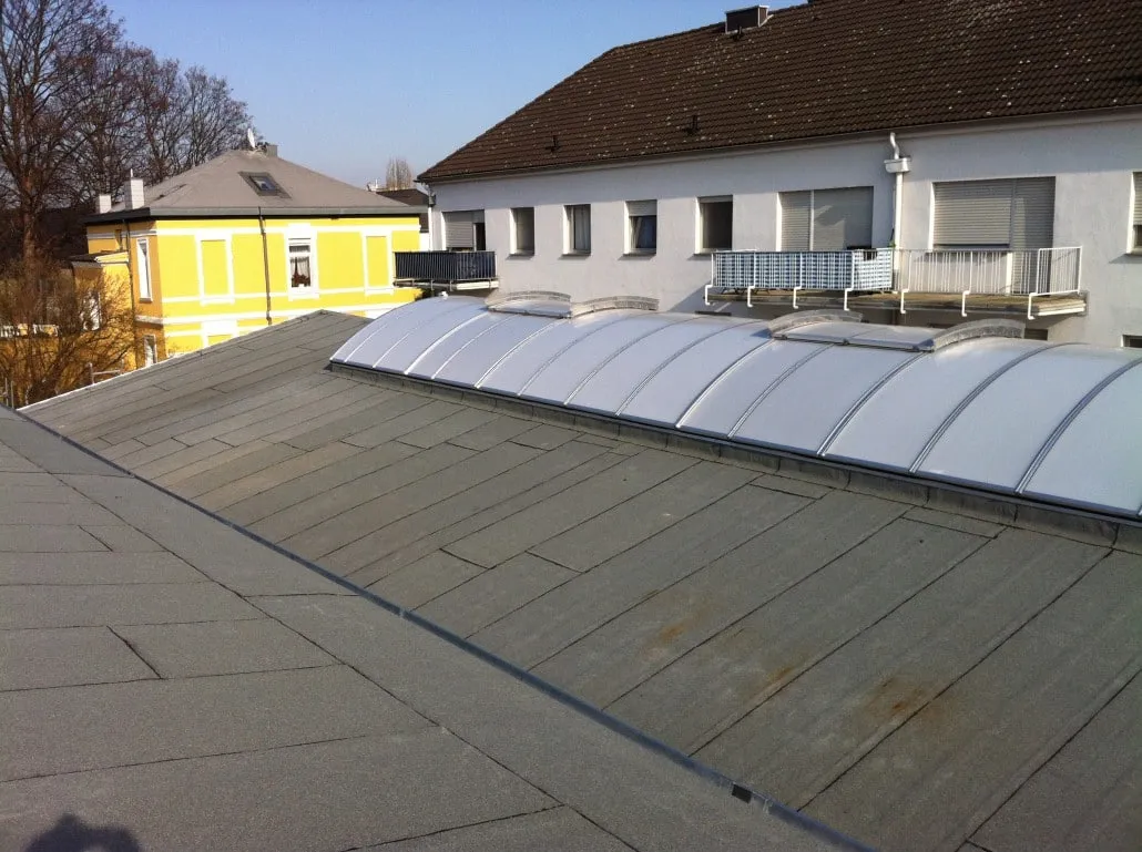Saniertes Flachdach mit Bitumenabdichtung und tonnenförmigem Lichtband über einem Gewerbeobjekt in Düren